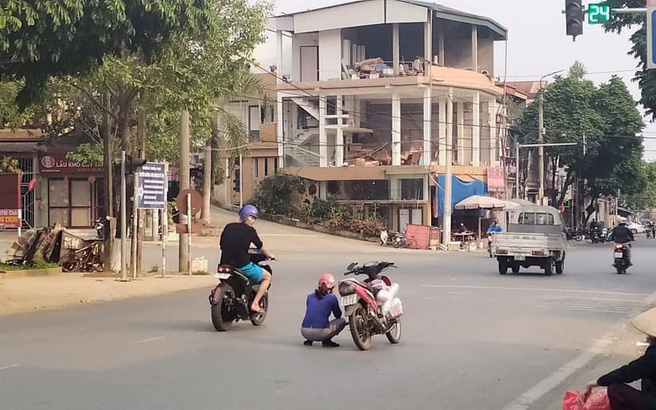 Đang đi xe máy, người phụ nữ bỗng nhảy xuống xe rồi ngồi giữa đường, hành động lạ kì này khiến ai nấy đều thắc mắc