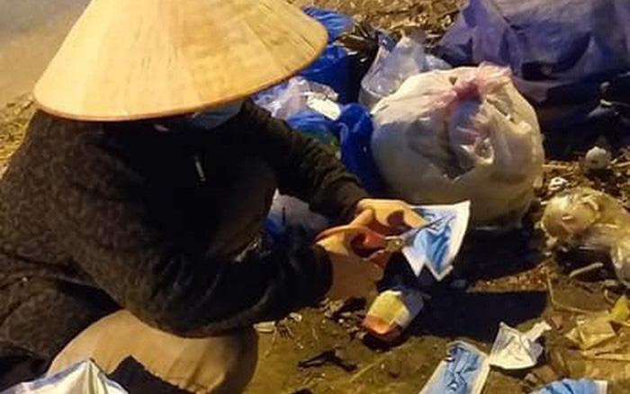 Người phụ nữ nhặt ve chai ngồi cắt đôi khẩu trang y tế vứt ở thùng rác và câu chuyện phía sau khiến nhiều người xấu hổ