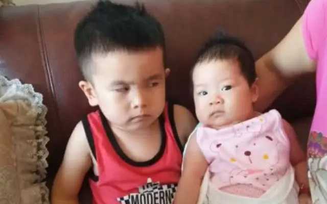 Anh trai lườm em gái mới sinh &quot;rách mặt&quot; vì bị ép làm một điều khiến mọi người không nhịn được cười