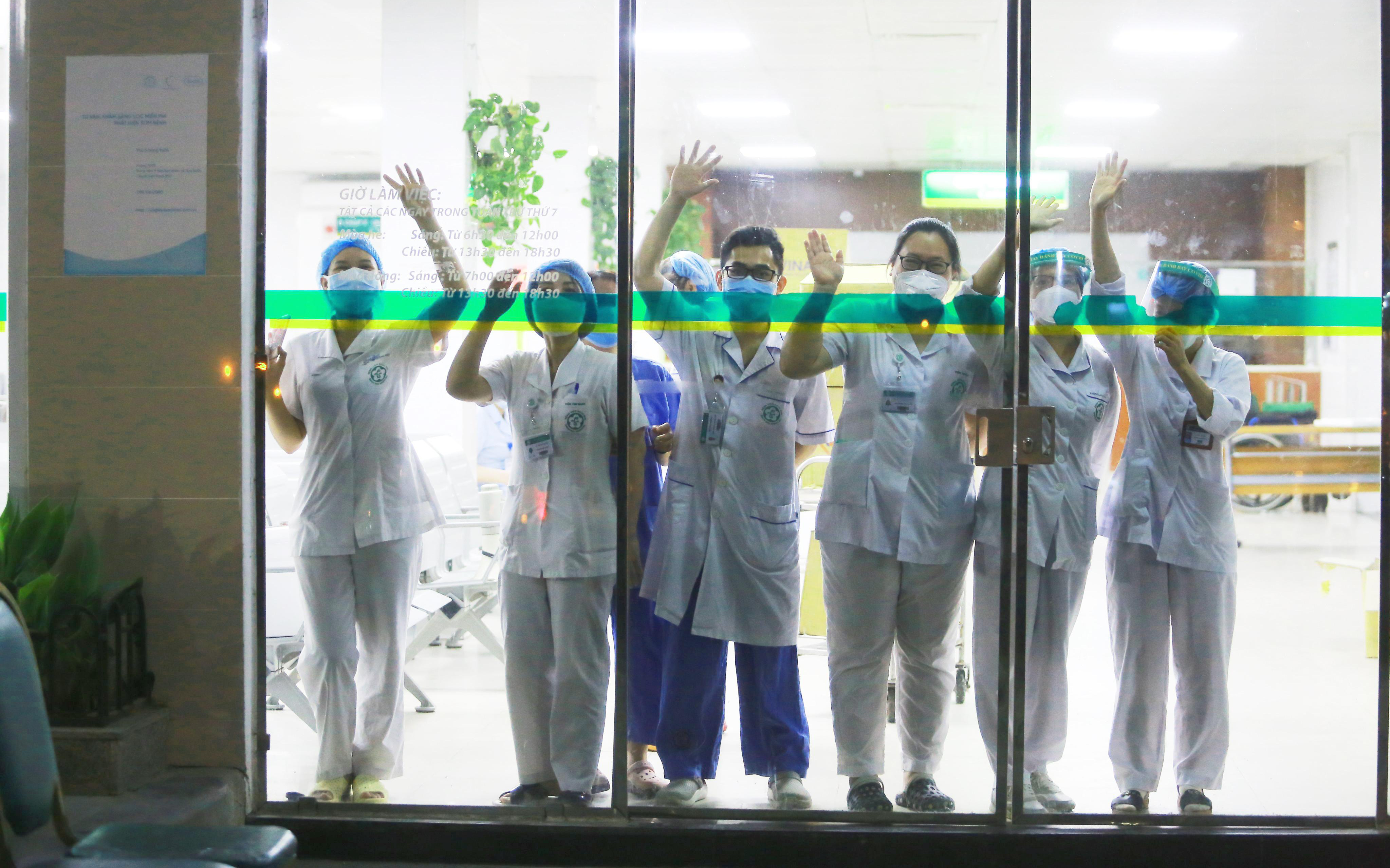 Hình ảnh các y bác sĩ tại Bệnh viện Bạch Mai vẫy tay chào qua cửa kính: Họ đang ngày đêm chiến đấu ở tuyến đầu nhưng vẫn luôn lạc quan như vậy