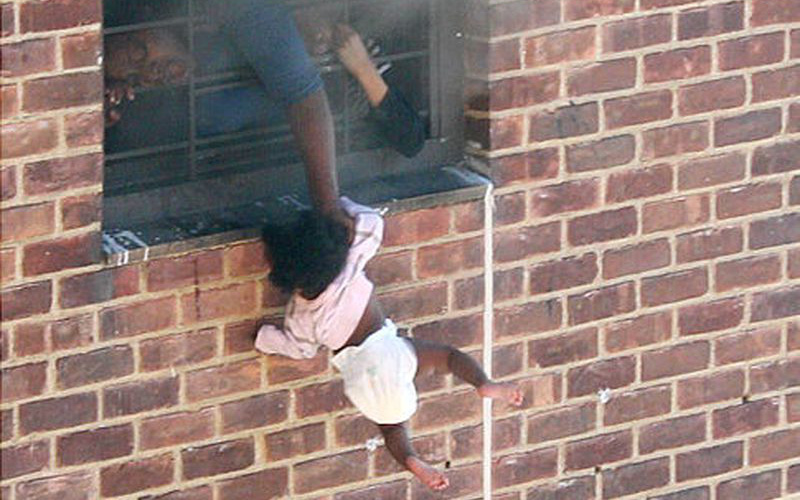 Bức ảnh đứa trẻ 7 tháng tuổi bị thả lủng lẳng ngoài cửa sổ được chia sẻ rầm rộ nhưng không phải ai cũng biết hoàn cảnh nó ra đời