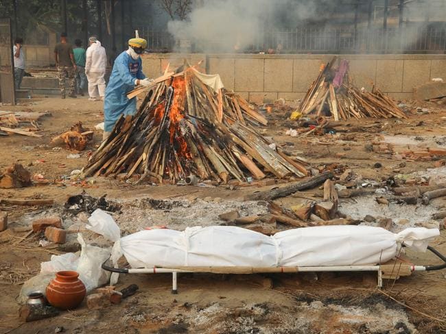 Hình ảnh gây sốc: Người phụ nữ gục chết tại ga tàu hỏa vì Covid-19, chồng vác xác vợ chết trên vai tìm đến nơi hỏa táng - Ảnh 4.