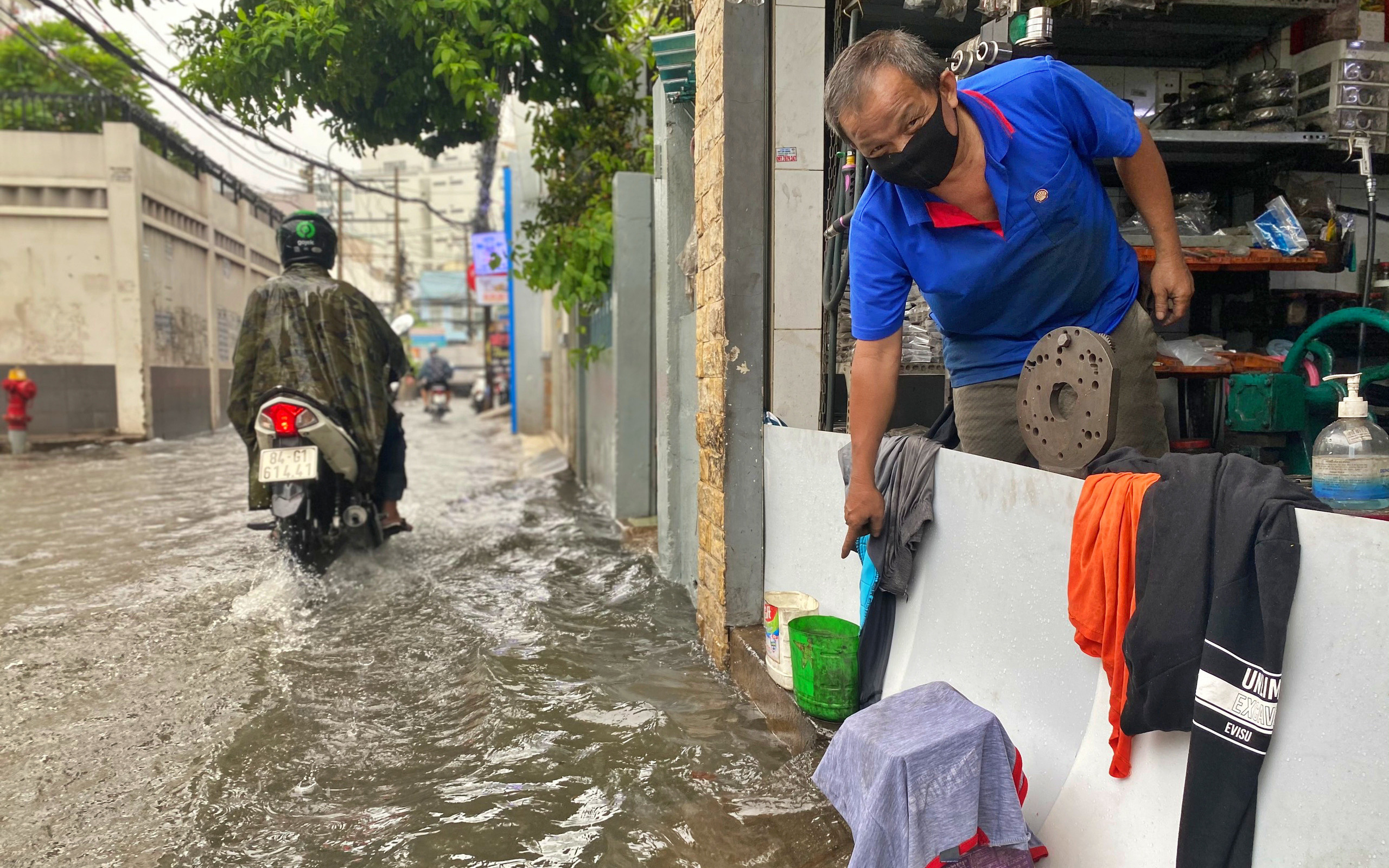 Mưa lớn liên tục nhiều giờ gây ngập sâu, người dân TP.HCM ngao ngán tìm cách chắn cửa ngăn nước tràn vào nhà