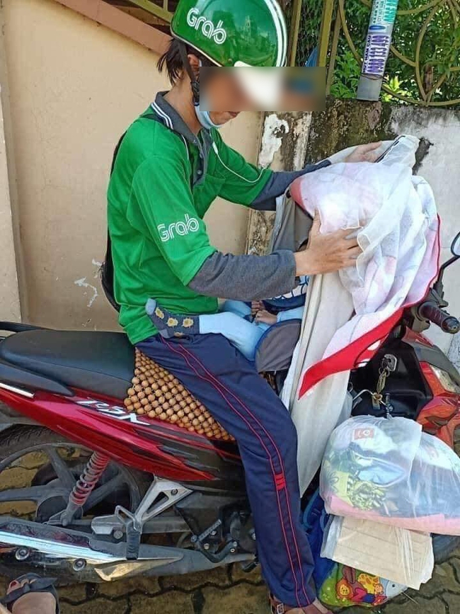 Nghẹn ngào với hình ảnh em bé 8 tháng tuổi nằm lọt thỏm trong chiếc xe máy, cùng cha mưu sinh trên đường mỗi ngày do hoàn cảnh khó khăn - Ảnh 1.