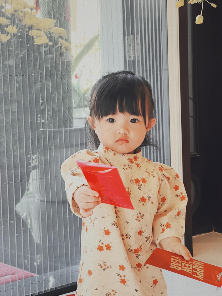 Con gái Đông Nhi xúng xính áo dài khoe lì xì Tết, biểu cảm hài hước khiến khán giả phì cười - Ảnh 2.